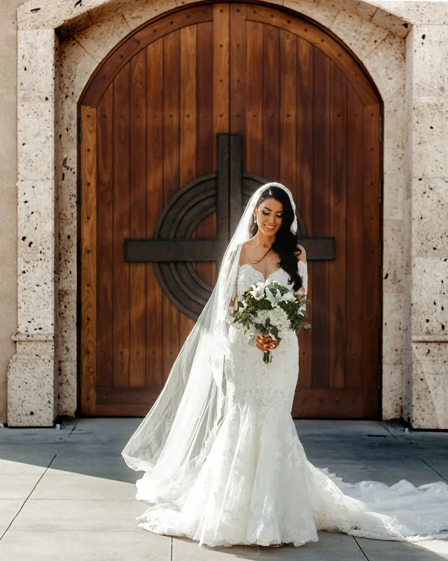 Novia frente a la puerta de madera de la iglesia