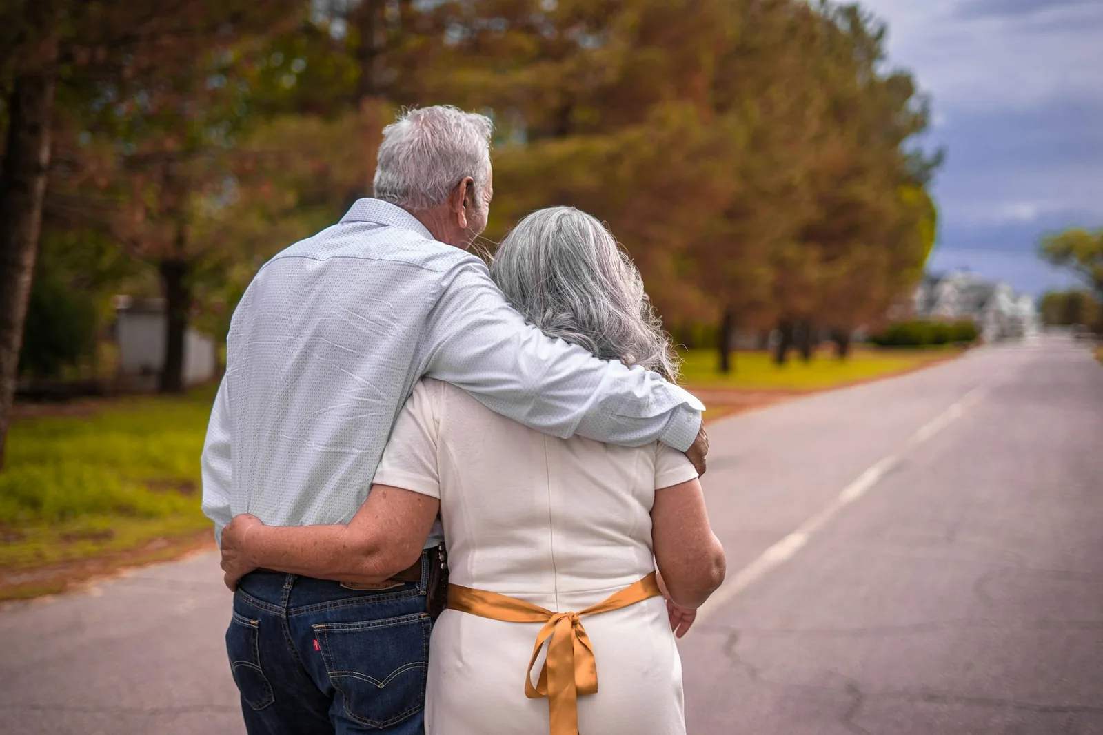 Pareja mayor abrazada caminando por una calle