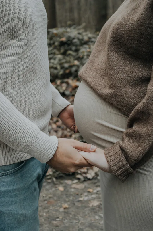 Manos de la pareja sobre la panza