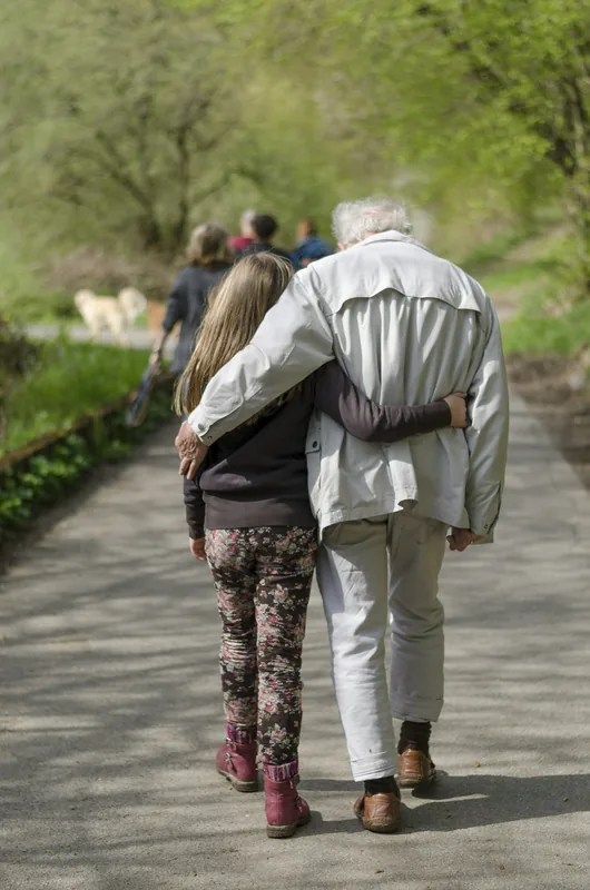 Abuelo y nieta caminando de espaldas