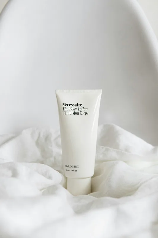 Pomo de crema sobre tela blanca