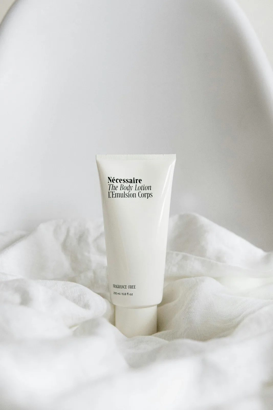 Pomo de crema sobre tela blanca